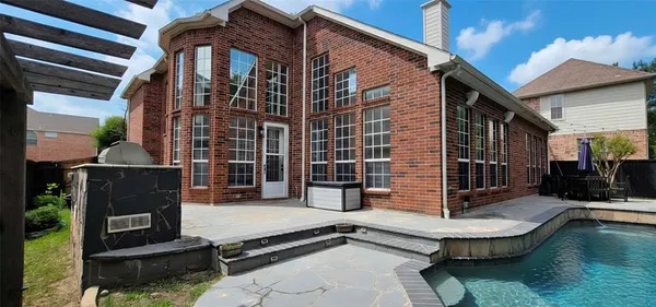 a front view of a house with swimming pool and porch