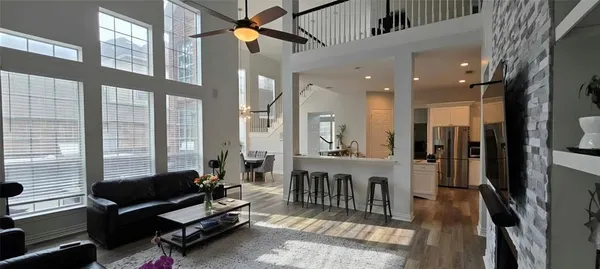 a living room with furniture a flat screen tv and a large window