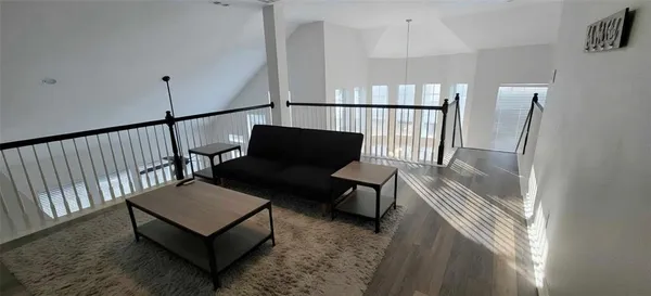a view of a hallway with wooden floor and furniture