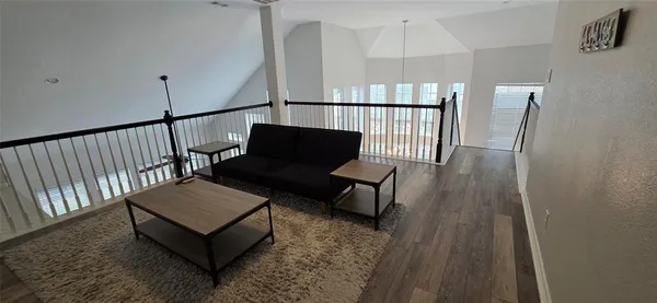 a view of a hallway with wooden floor and furniture