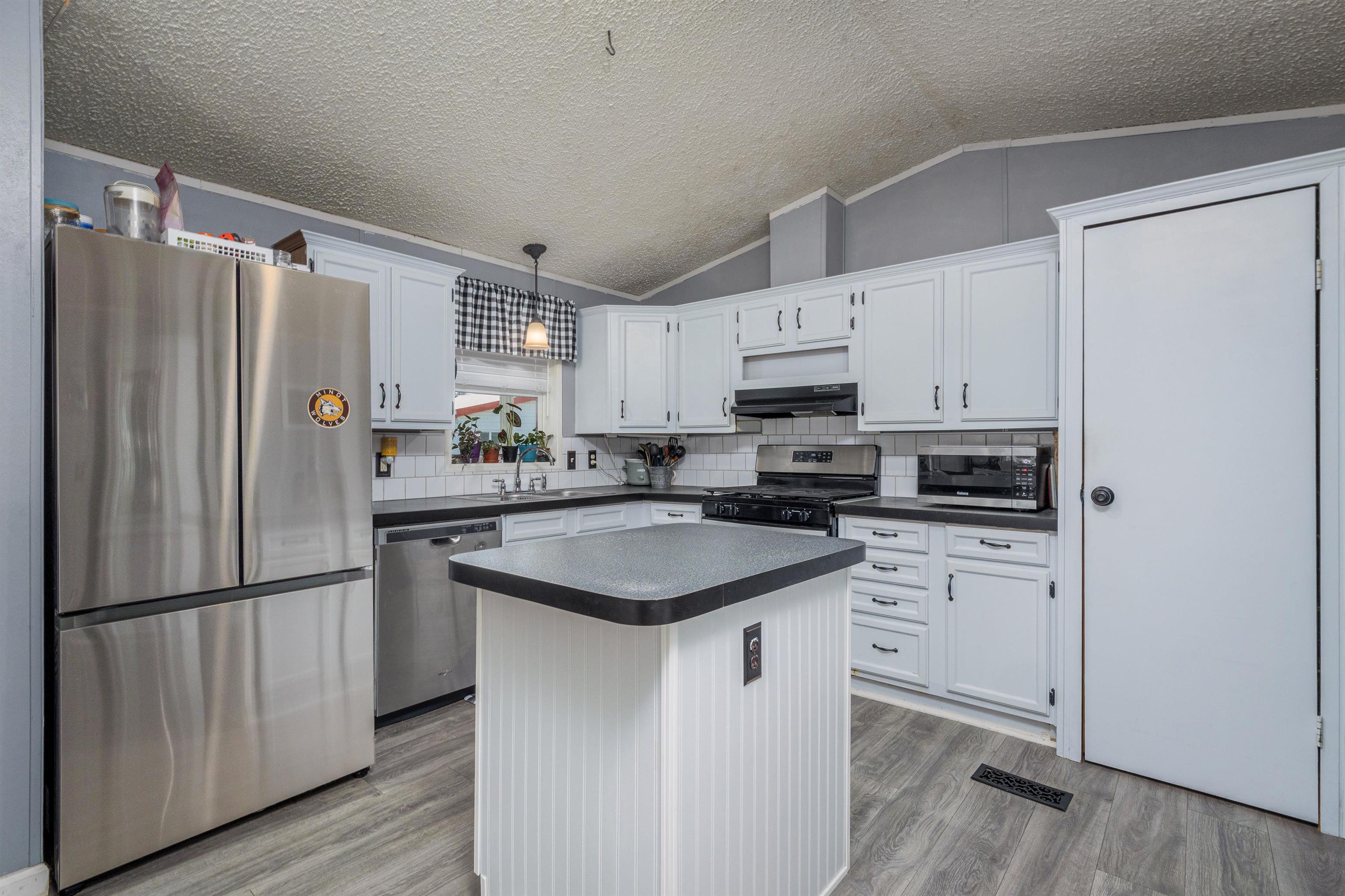 435 32 Road, Unit 705 Clifton, CO 81520 - Photo 10 of 25 a kitchen with stainless steel appliances granite countertop a refrigerator a sink dishwasher a stove and white cabinets with wooden floor