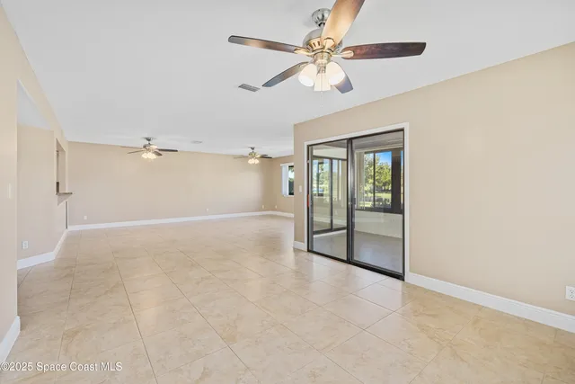 an empty room with fan and windows