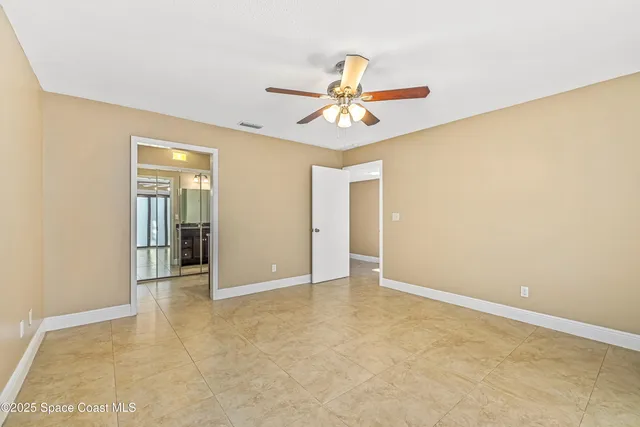 an empty room with closet and a ceiling fan
