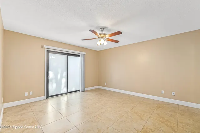 an empty room with closet and a ceiling fan