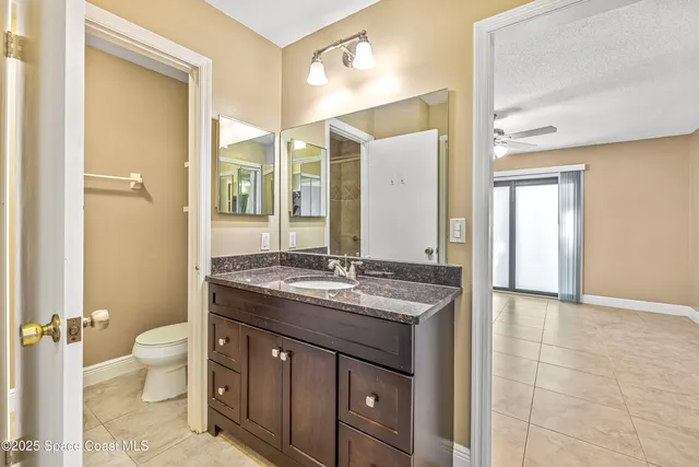a spacious bathroom with a granite countertop sink toilet and shower