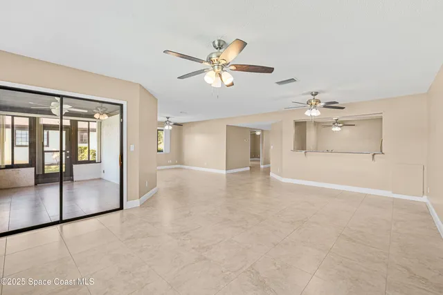 an empty room with fan and windows