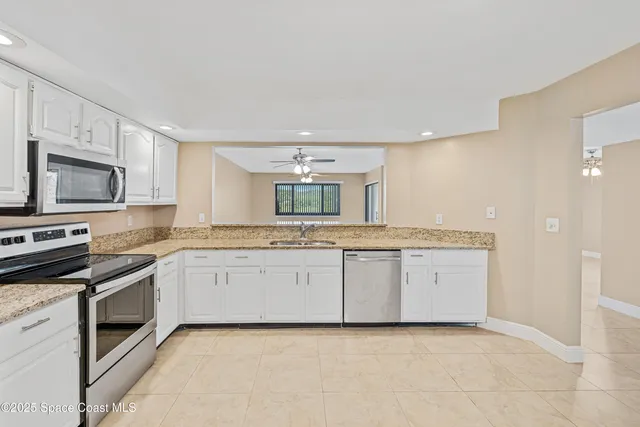 a kitchen with granite countertop a sink and stainless steel appliances