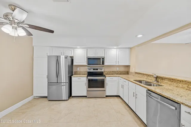 a kitchen with stainless steel appliances granite countertop a refrigerator and a stove top oven