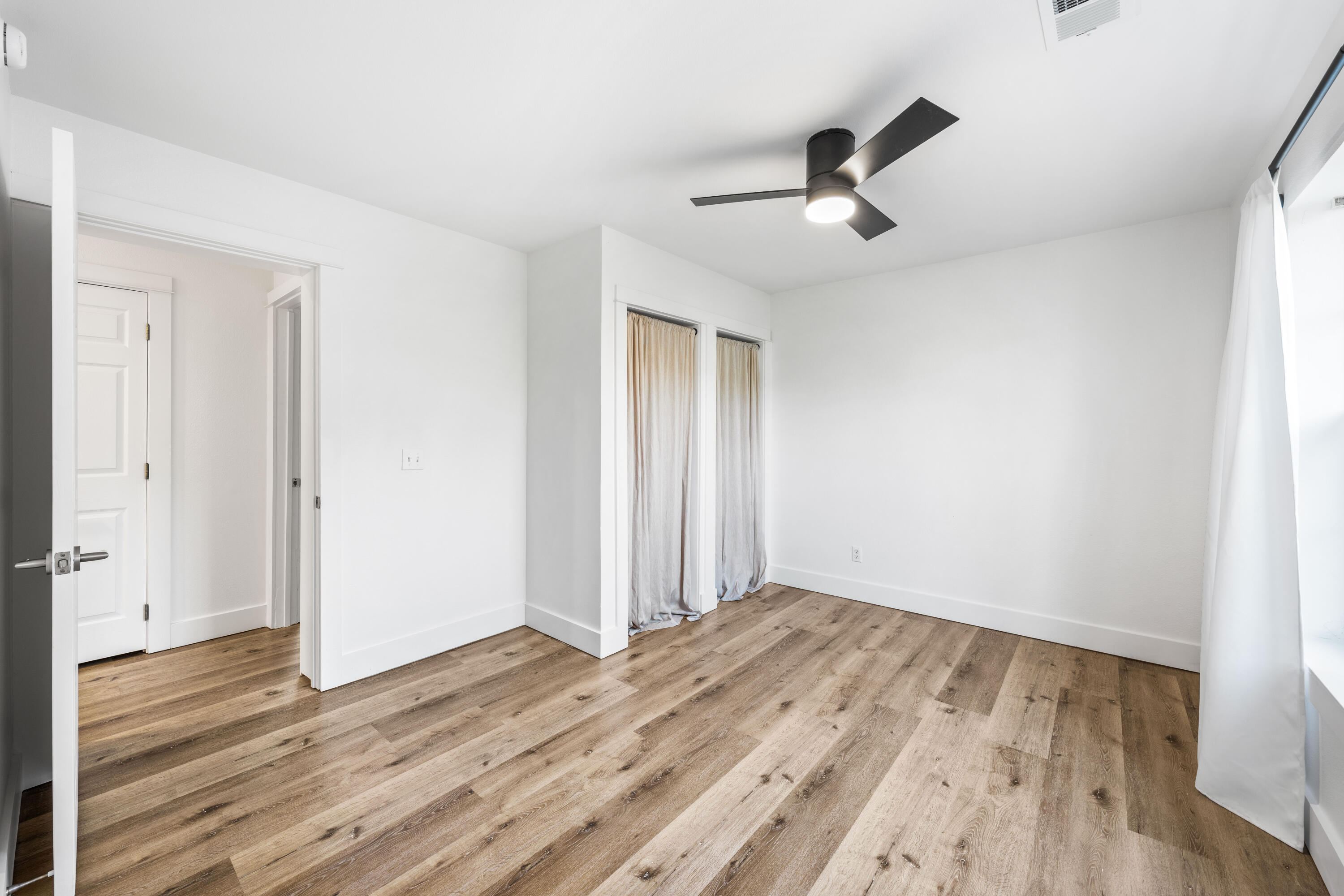 230 Plantation Way Santa Rosa Beach, FL 32459 - Photo 18 of 29 an empty room with wooden floor ceiling fan and windows