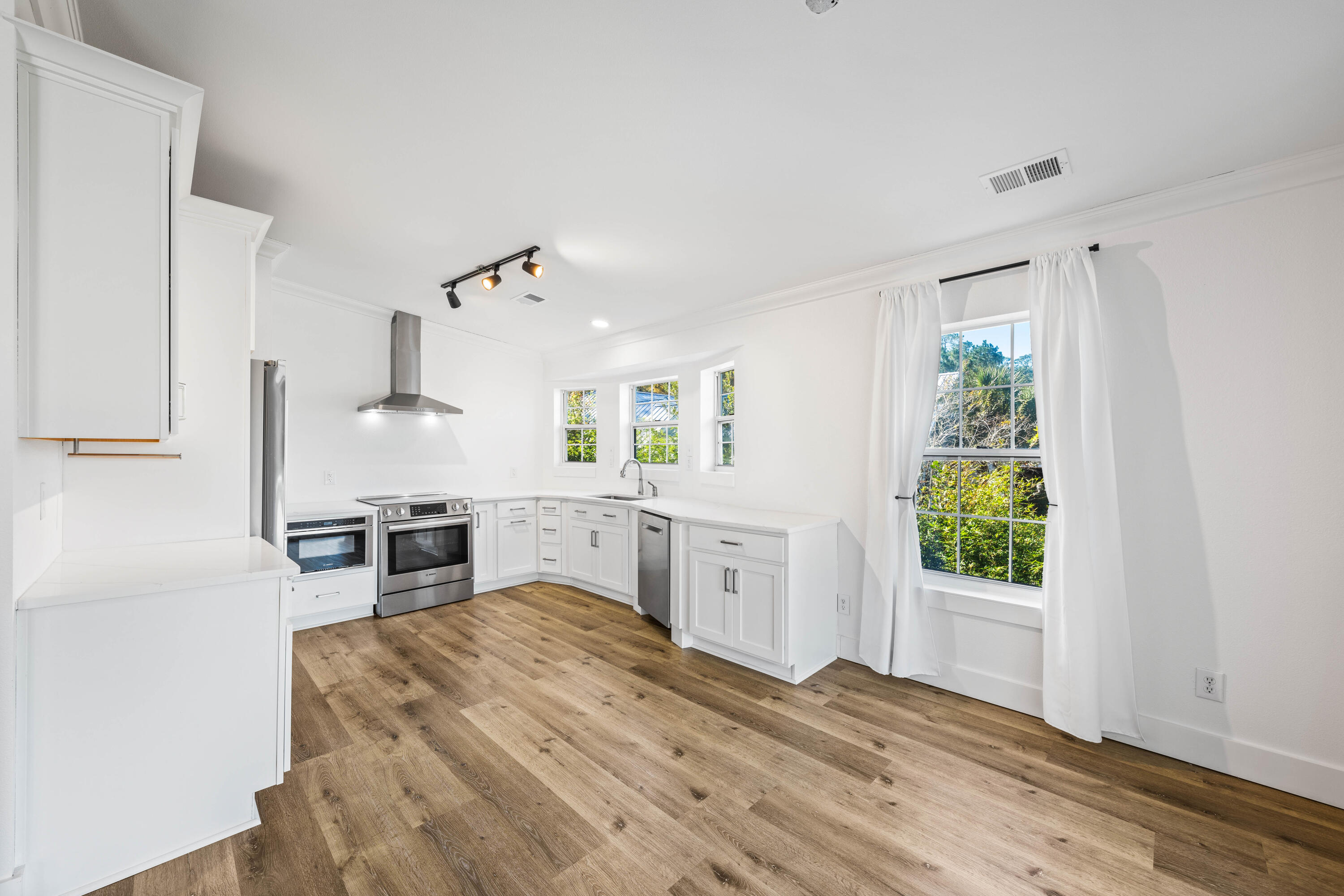 230 Plantation Way Santa Rosa Beach, FL 32459 - Photo 5 of 29 a large white kitchen with sink and cabinets