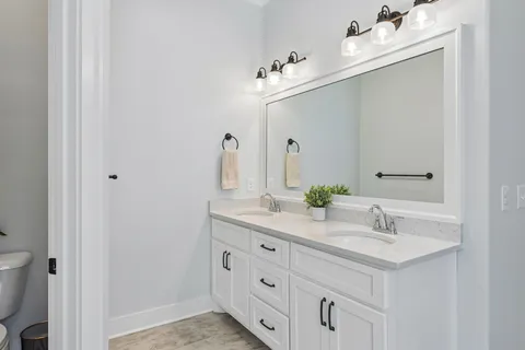 a bathroom with a double vanity sink and a mirror
