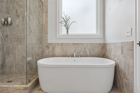 a white bath tub sitting next to a shower