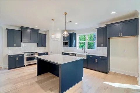 a kitchen with stainless steel appliances granite countertop a stove a sink a refrigerator and a oven