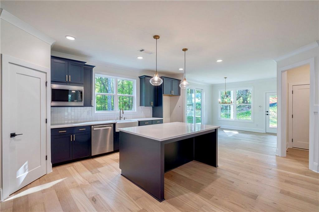 1709 Eastside Parc Street Atlanta, GA 30316 - Photo 17 of 38 a kitchen with stainless steel appliances kitchen island granite countertop a stove a sink dishwasher a refrigerator and a oven with wooden floor