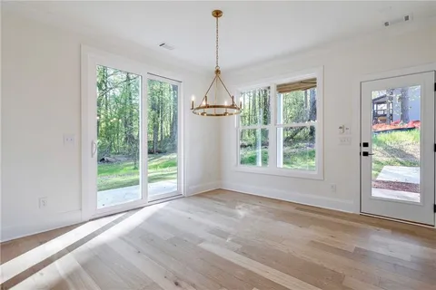 a dining room with wooden floor windows and outdoor view