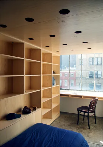 a room with a book shelf and a wooden floor
