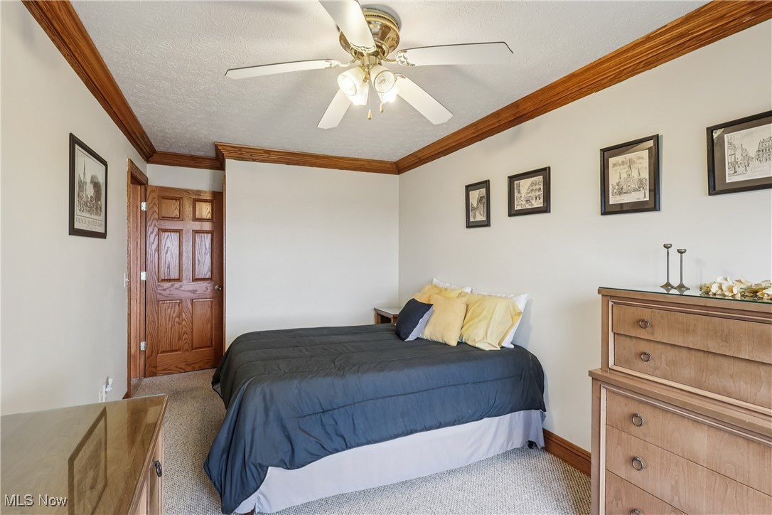 337 Cedar Point Road Sandusky, OH 44870 - Photo 7 of 50 Carpeted bedroom with crown molding, a textured ceiling, and ceiling fan