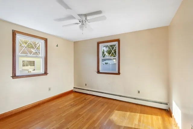 a view of empty room with wooden floor