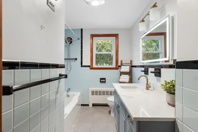 a spacious bathroom with a double vanity sink a mirror and a bathtub