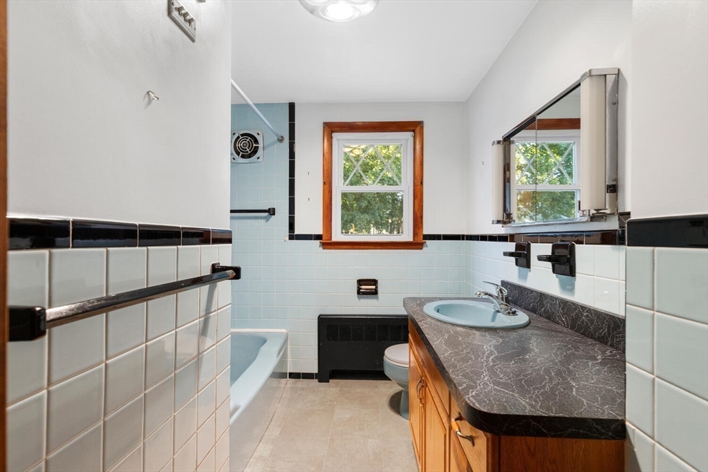 10 Horton Street Salem, MA 01970 - Photo 18 of 26 a bathroom with a granite countertop sink a mirror and a bathtub