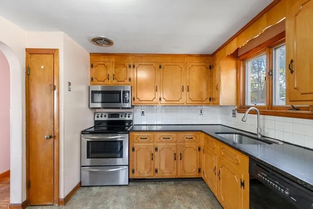 a kitchen with stainless steel appliances granite countertop a stove and a refrigerator