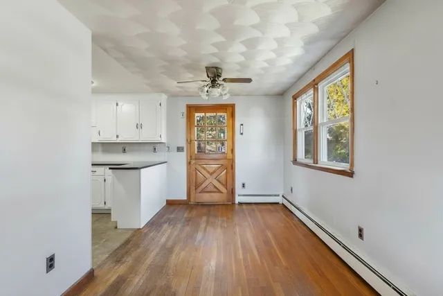 a view of a kitchen with wooden floor and a window