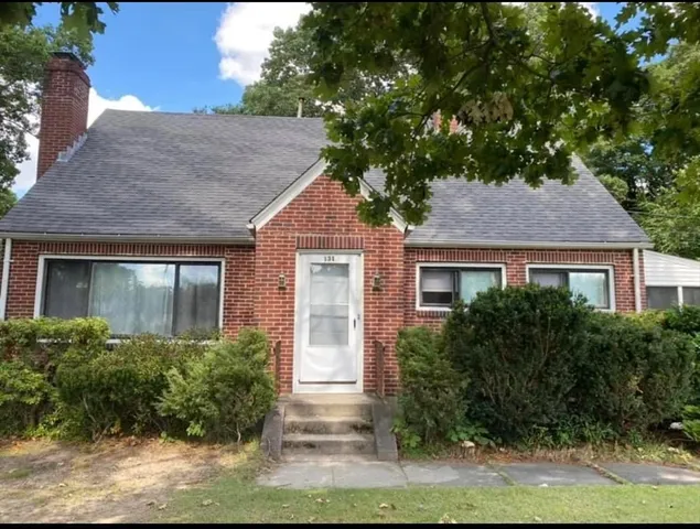 a front view of house with yard and trees around