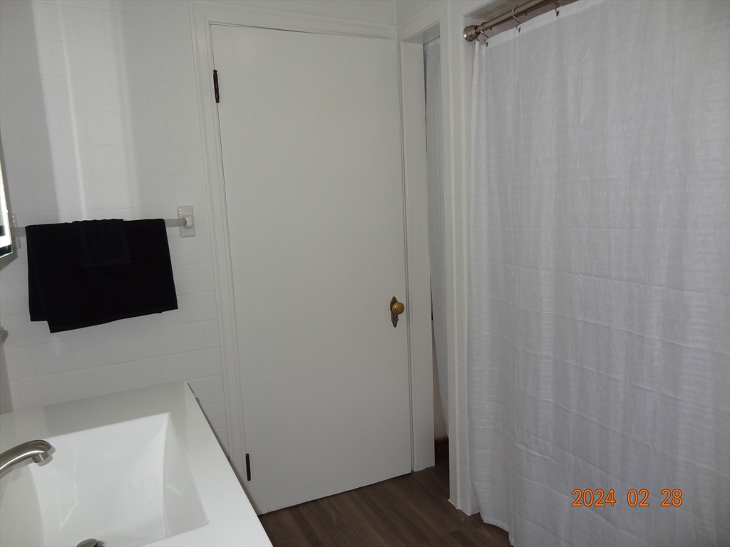 131 Worcester-Providence Turnpike, Unit 1 Millbury, MA 01527 - Photo 11 of 18 a bathroom with a sink and a shower curtain