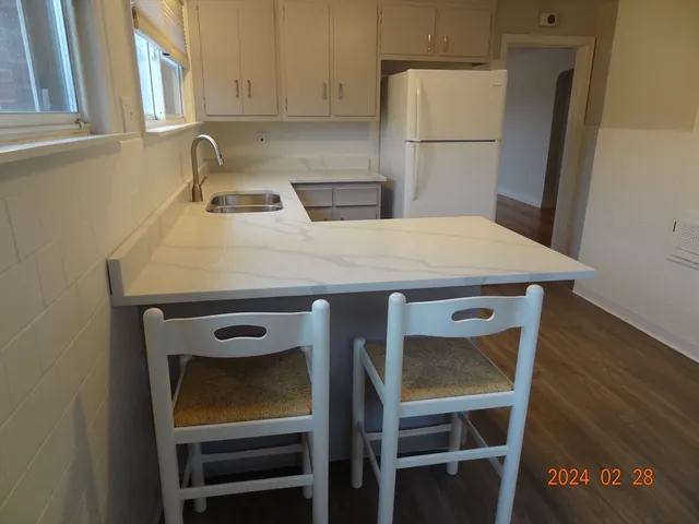 a kitchen with a sink a refrigerator and cabinets