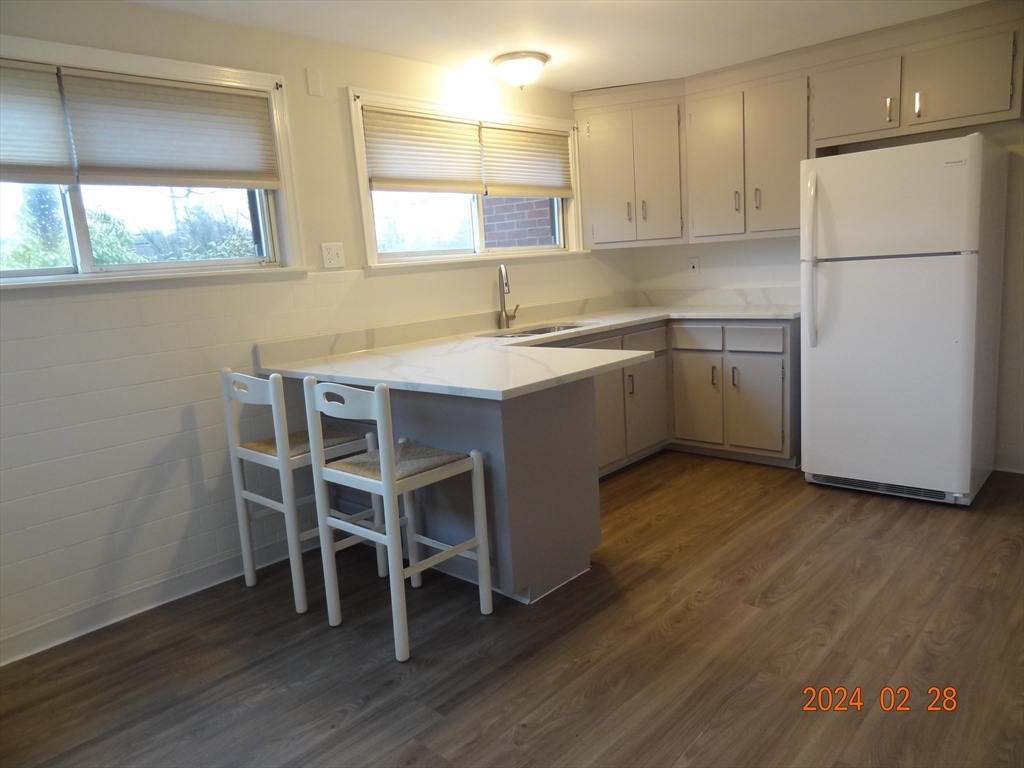 131 Worcester-Providence Turnpike, Unit 1 Millbury, MA 01527 - Photo 13 of 18 a kitchen with a sink a refrigerator and wooden floor