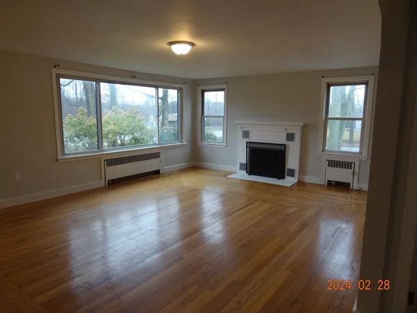 wooden floor fireplace and windows in an empty room
