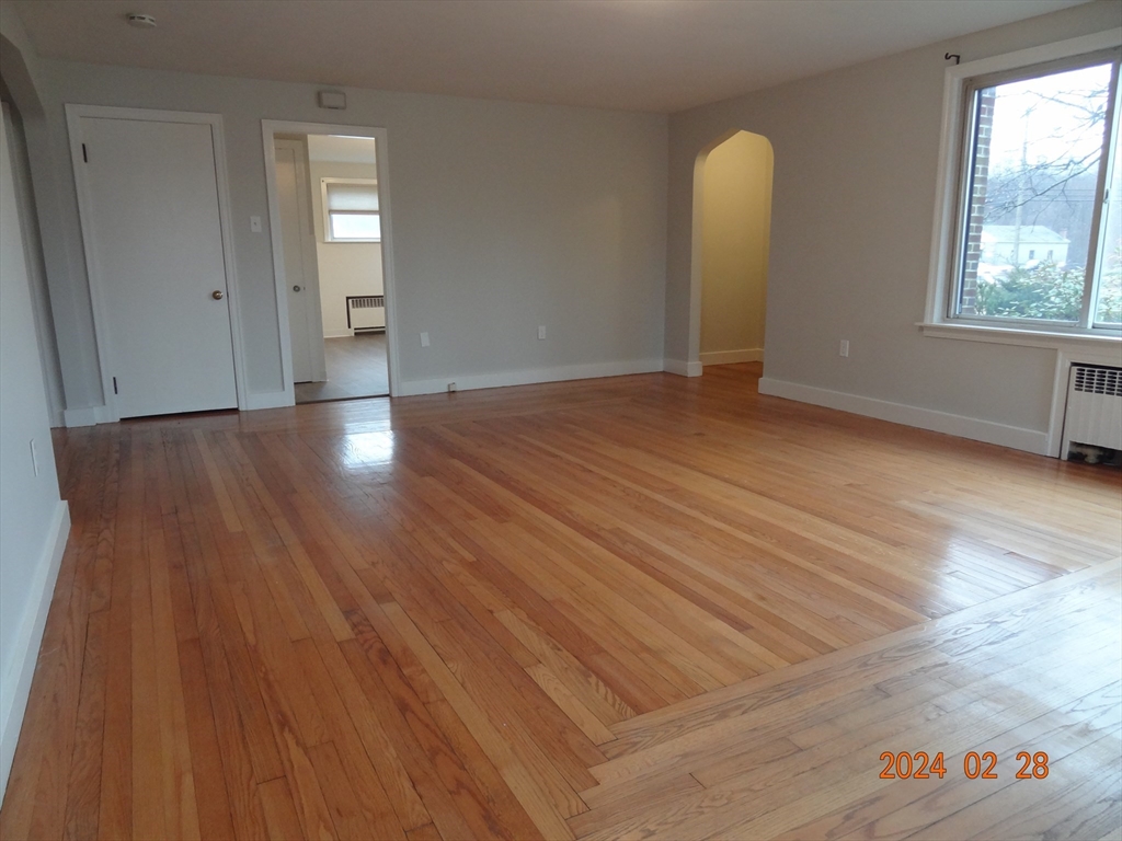 131 Worcester-Providence Turnpike, Unit 1 Millbury, MA 01527 - Photo 4 of 18 an empty room with wooden floor and windows
