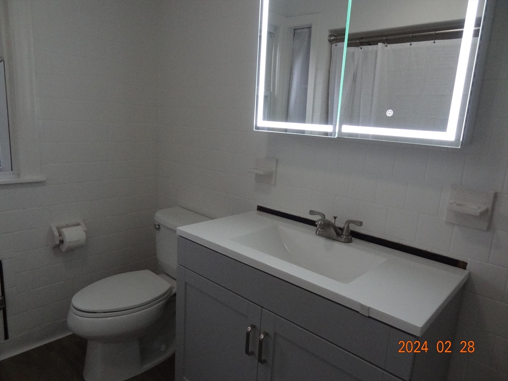 131 Worcester-Providence Turnpike, Unit 1 Millbury, MA 01527 - Photo 9 of 18 a bathroom with a sink a toilet and a mirror