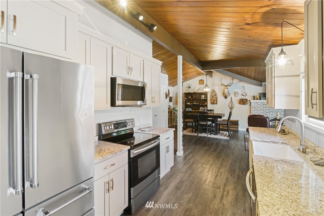 43825 Fir Road Gold Bar, WA 98251 - Photo 17 of 35 a kitchen with stainless steel appliances granite countertop a refrigerator a stove and a wooden floors