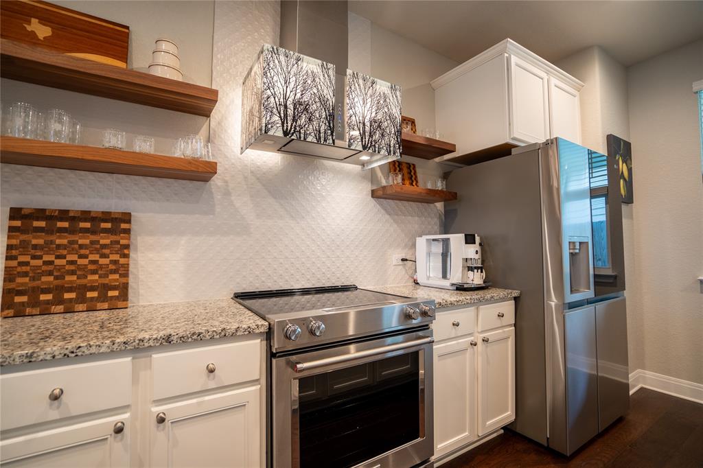 1215 Davis Street Taylor, TX 76574 - Photo 13 of 31 a kitchen with stainless steel appliances granite countertop a stove and a refrigerator