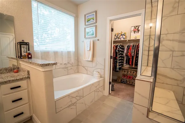 a bathroom with a tub a sink and a window