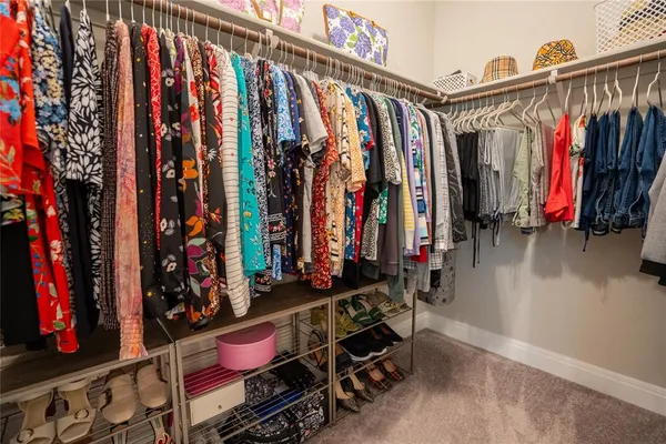 a view of walk in closet with clothes
