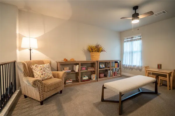 a spacious bedroom with a bed a couch and a chandelier