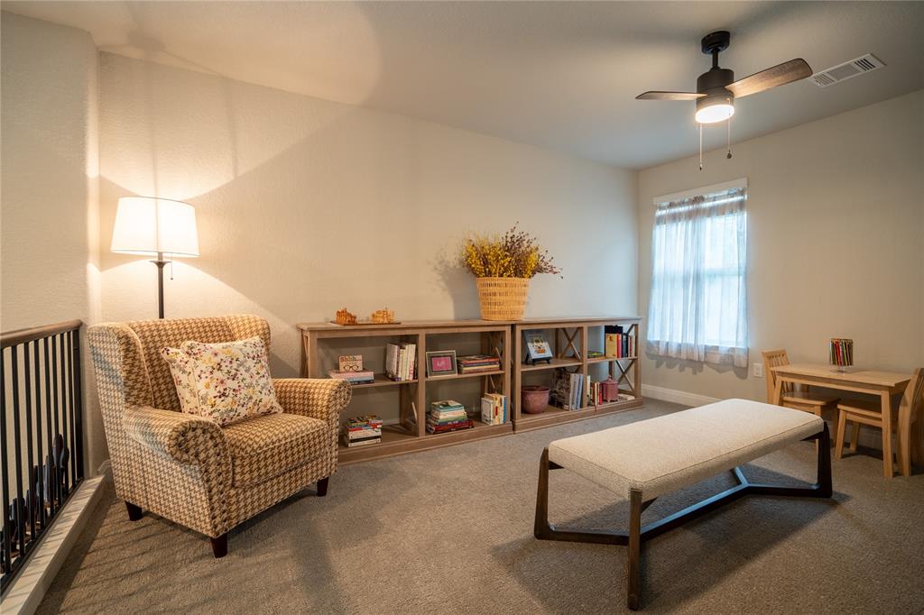 1215 Davis Street Taylor, TX 76574 - Photo 24 of 31 a spacious bedroom with a bed a couch and a chandelier