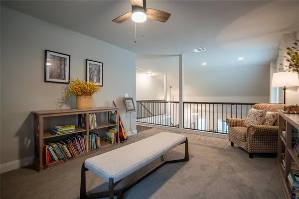 a living room with furniture and a book shelf