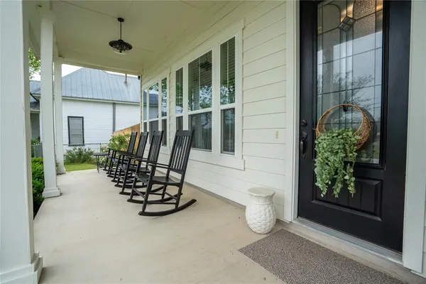 a view of a porch with a table and chairs and potted plants