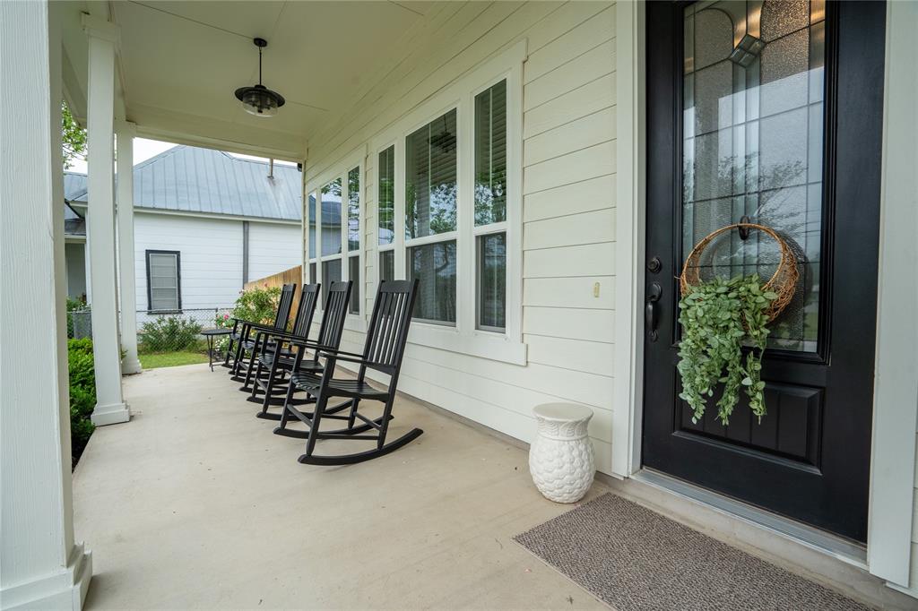 1215 Davis Street Taylor, TX 76574 - Photo 3 of 31 a view of a porch with a table and chairs and potted plants