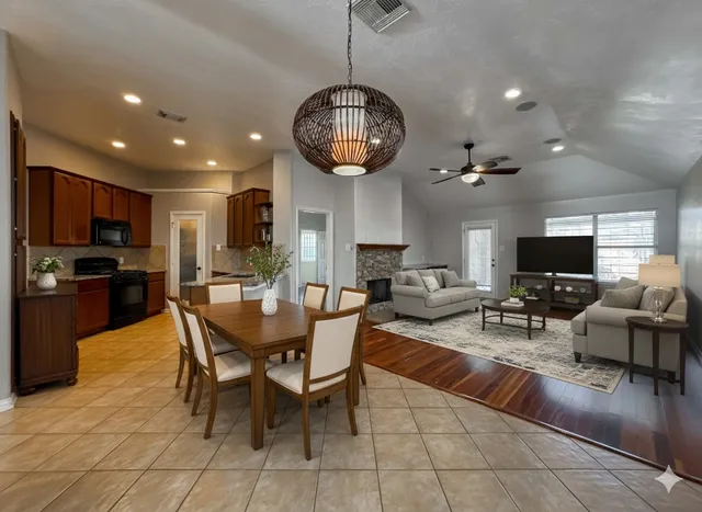 a view of a dining room with furniture a kitchen and chandelier