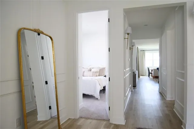 a view of a hallway with wooden floor and furniture