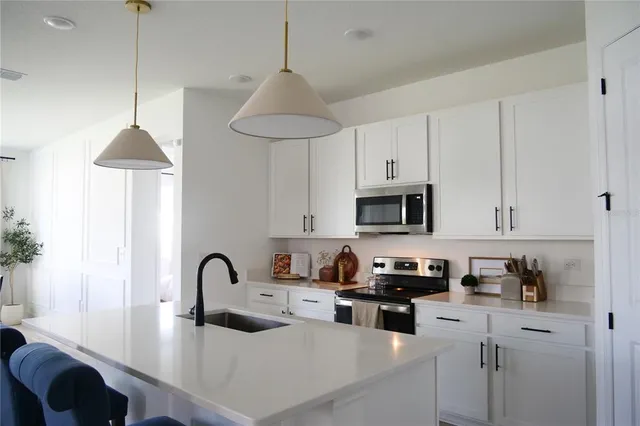 a kitchen with stainless steel appliances granite countertop a sink a stove and a refrigerator
