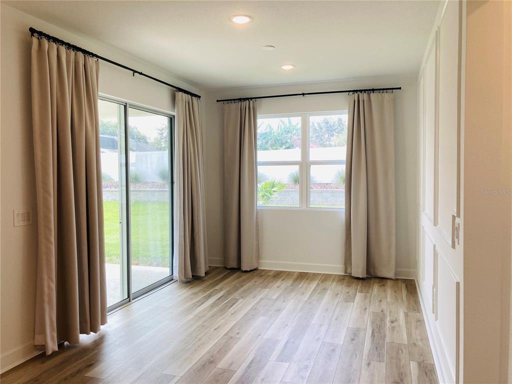 10337 Church Hammock Road Leesburg, FL 34788 - Photo 4 of 21 a view of an empty room with wooden floor and a window
