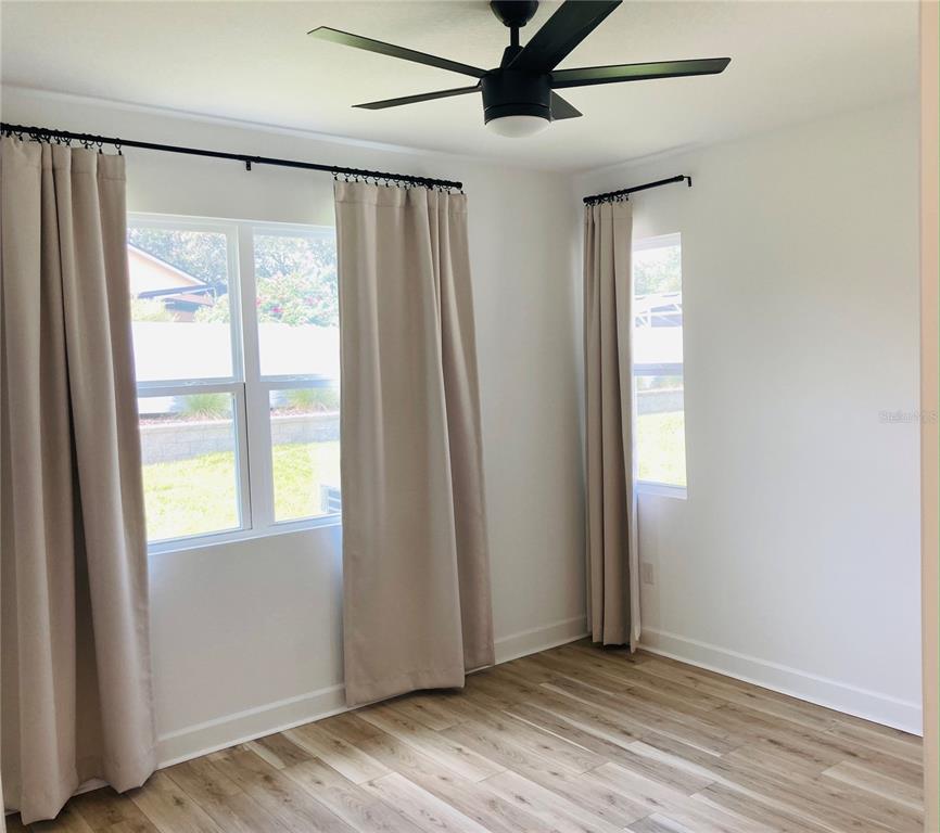 10337 Church Hammock Road Leesburg, FL 34788 - Photo 9 of 21 an empty room with wooden floor and windows