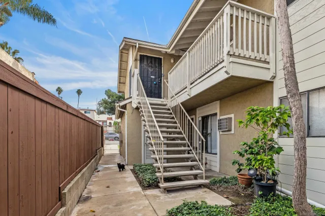 a view of a house with wooden stairs and a small yard