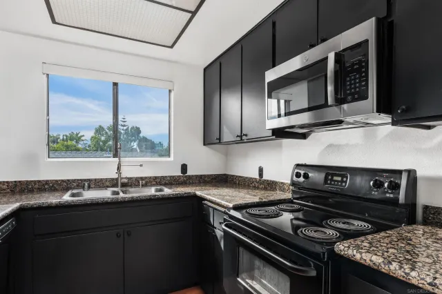 a kitchen with stainless steel appliances granite countertop a stove and a microwave