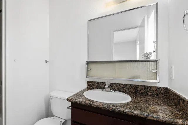 a bathroom with a granite countertop sink and a mirror
